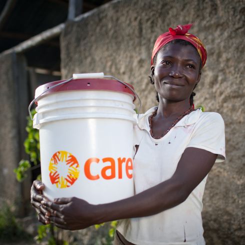 Une femme tient un colis hygiène dans ses bras
