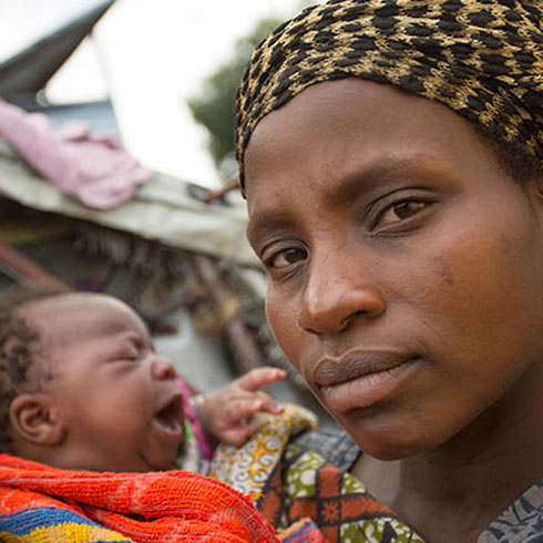 Une mère tiens son enfant dans ses bras