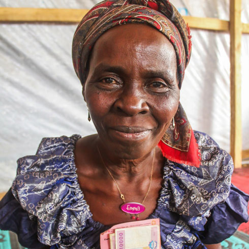 Une femme tient quelques billets dans ses mains.