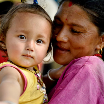 Une femme portant un petit enfant dans ses bras.