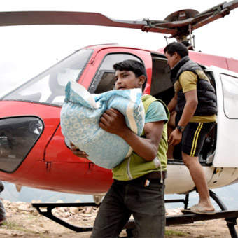 garçon aide à décharger des produits de secours d'un hélicopter. 