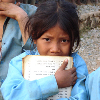 Une fille porte un cahier scolaire.