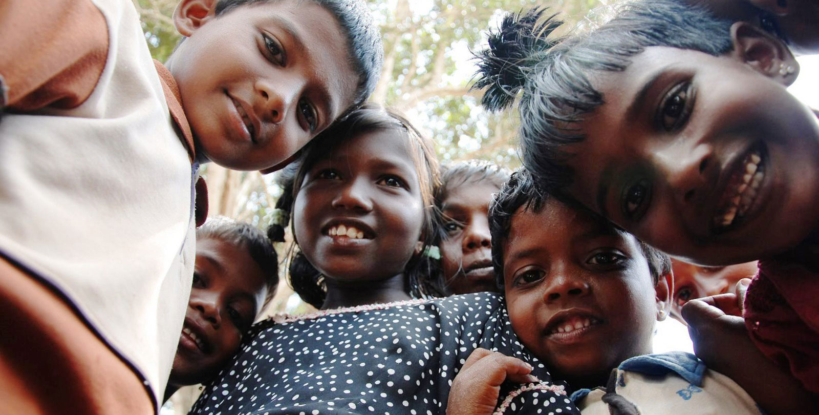 Des enfants souriants regardant droit dans l'objectif.