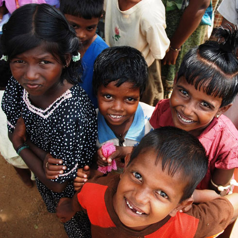 Un groupe d'enfants rit en regardant droit dans l'objectif.