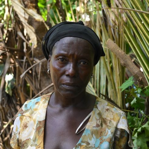 Une femme se trouve devant une plantation ravagée par l'ouragan Matthew