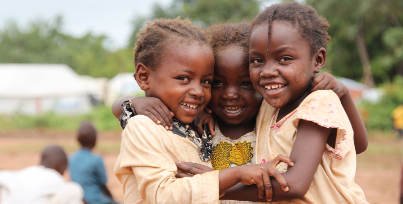 Trois enfants tchadiens s'entrelacent.