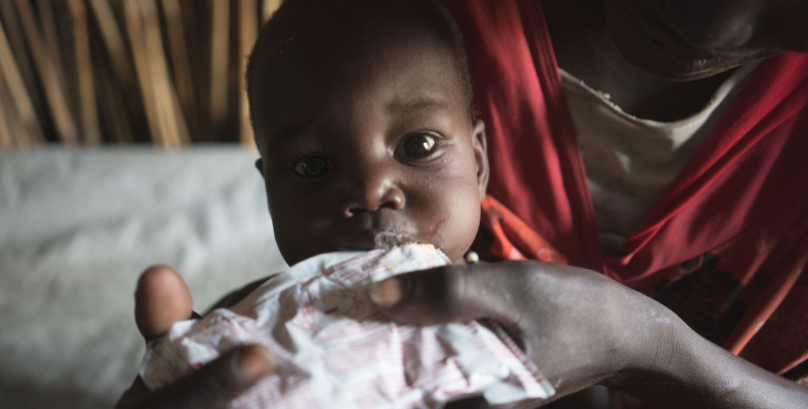 Un jeune enfant mange de la nourriture fortifiante à base d'arachide